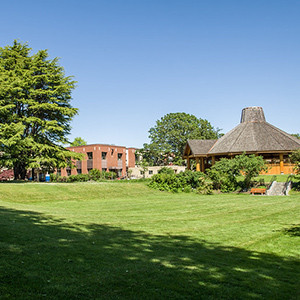 A large park like lawn with trees in the background.