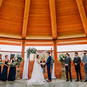 A bride and groom exchange vows in an outdoor ceremony. 