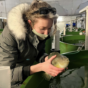 Arts and Science student holding a fish on their co-op work term