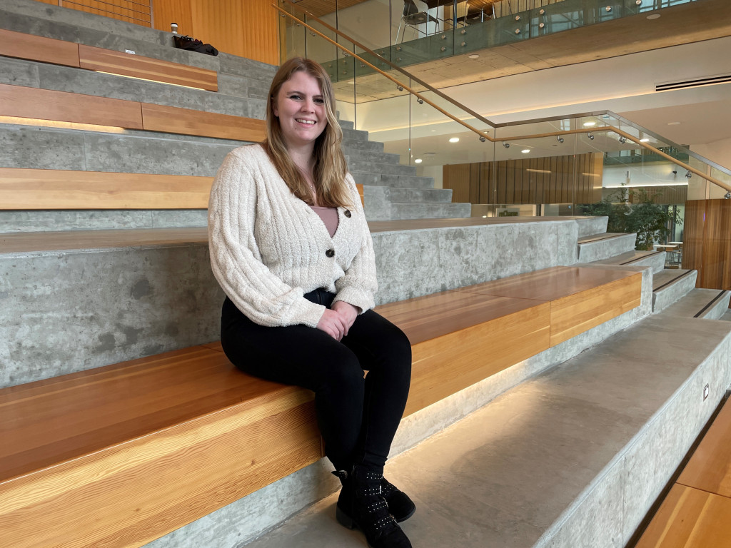 Portrait of a woman sitting on a wooden stair case