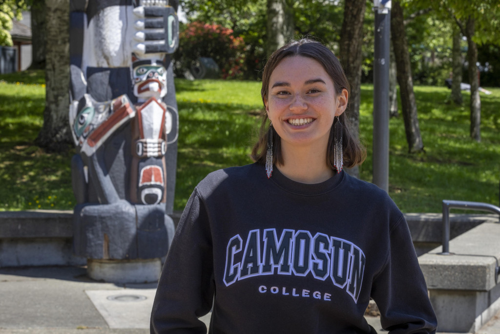 Keelin standing outdoors, in front of the Totem Pole in Interurban Campus