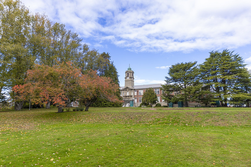 Photgraph of the Lansdowne campus taken in fall with the Young Building in the background surrounded by trees and a green lawn in the foreground.