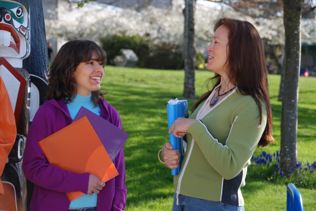 Indigenous student and instructor chatting outside