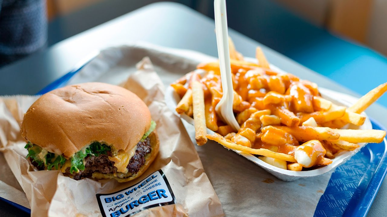 A cheese burger with a side of poutine