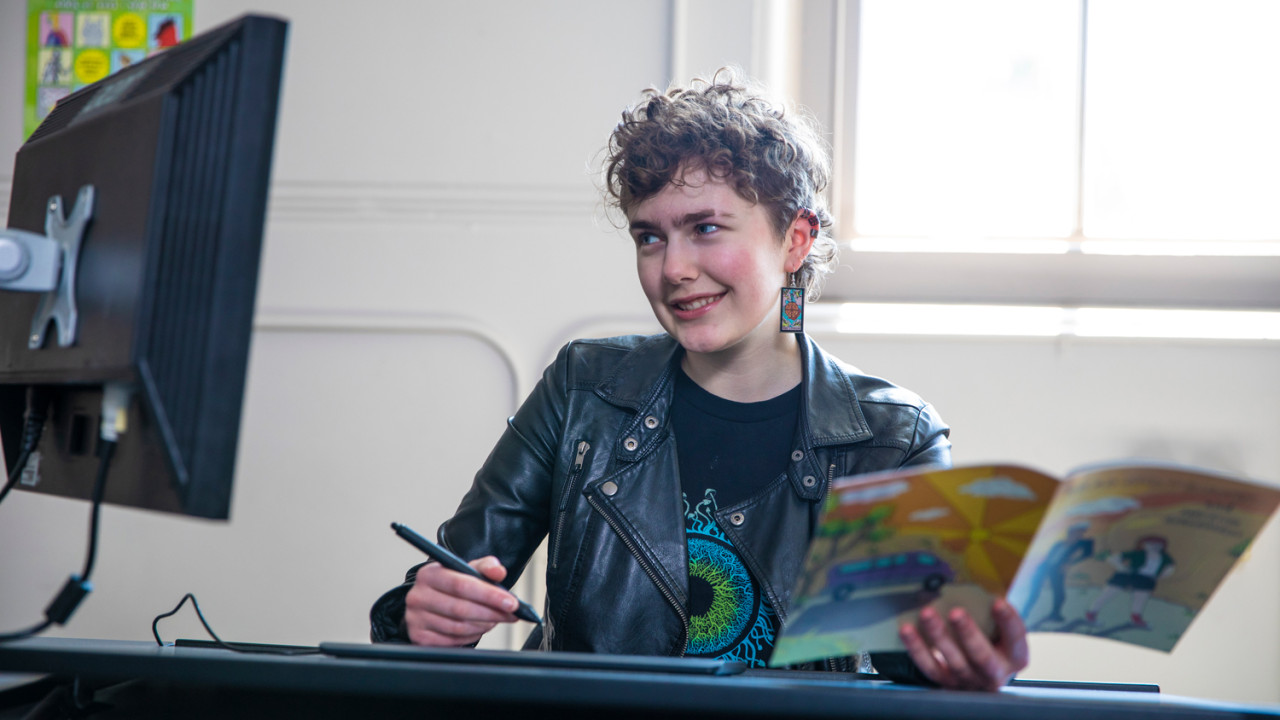 A young woman drawing on a computer.