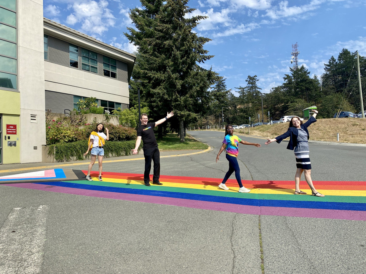 Students and college administrators walk across the pride crosswalk