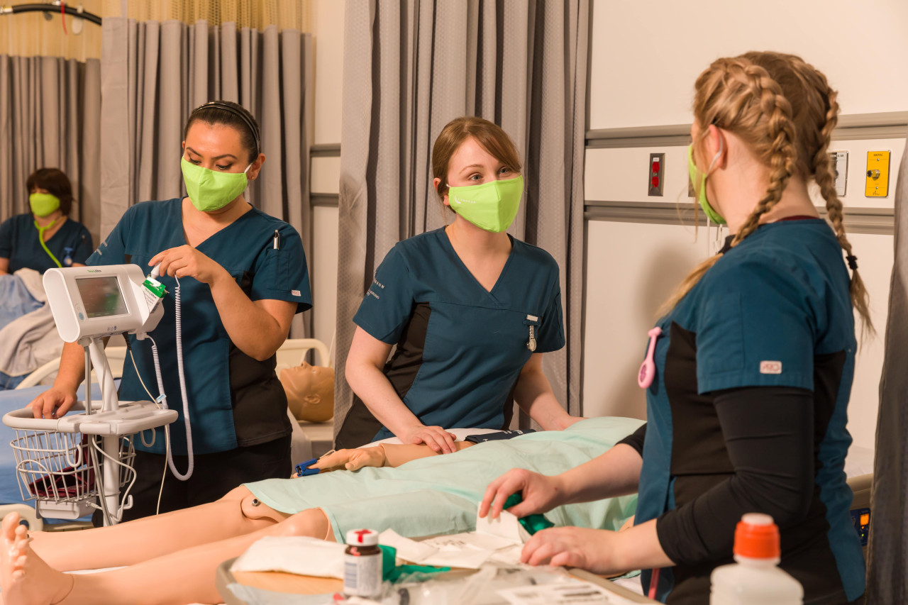 Three students practicing in a simulation lab