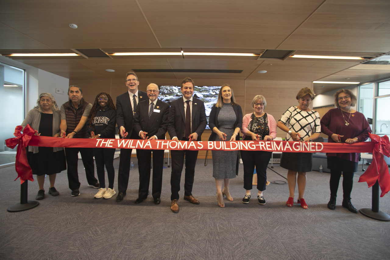 A group of Elders, students, faculty and staff cut a ribbon in the new Wilna Thomas gathering hall