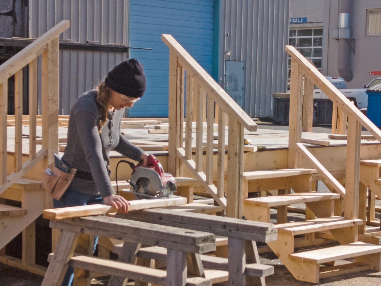 A carpentry student saws wood at Camosun.