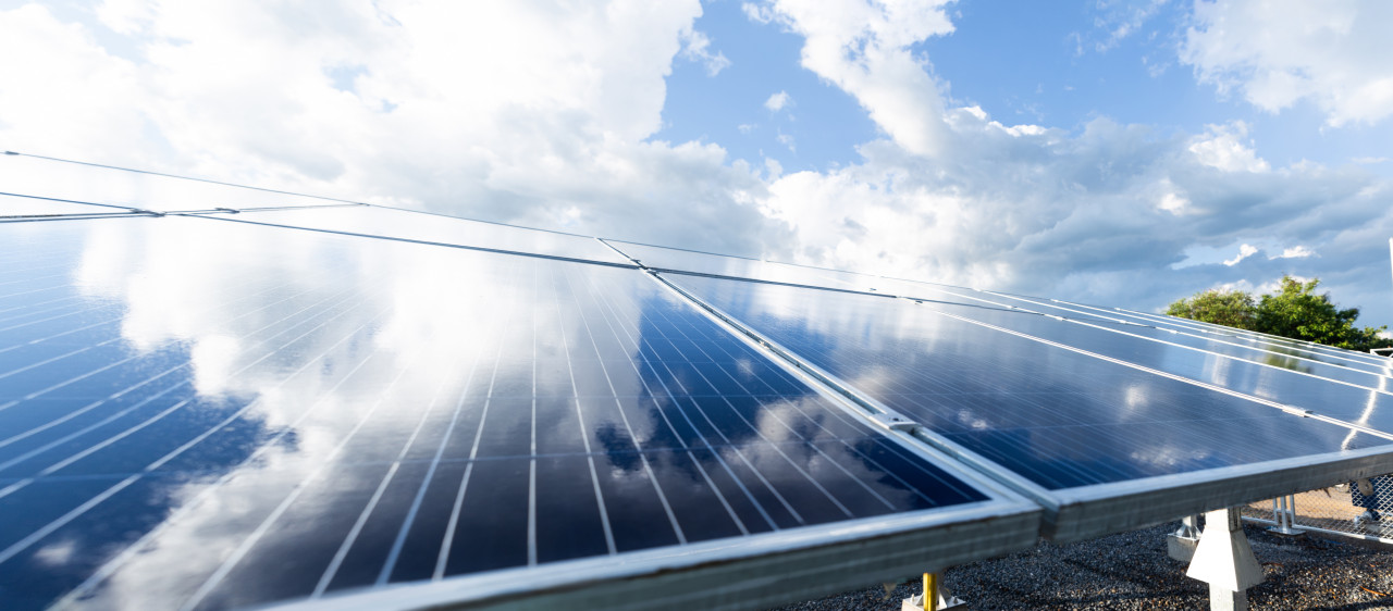 Solar panel reflecting blue sky and clouds