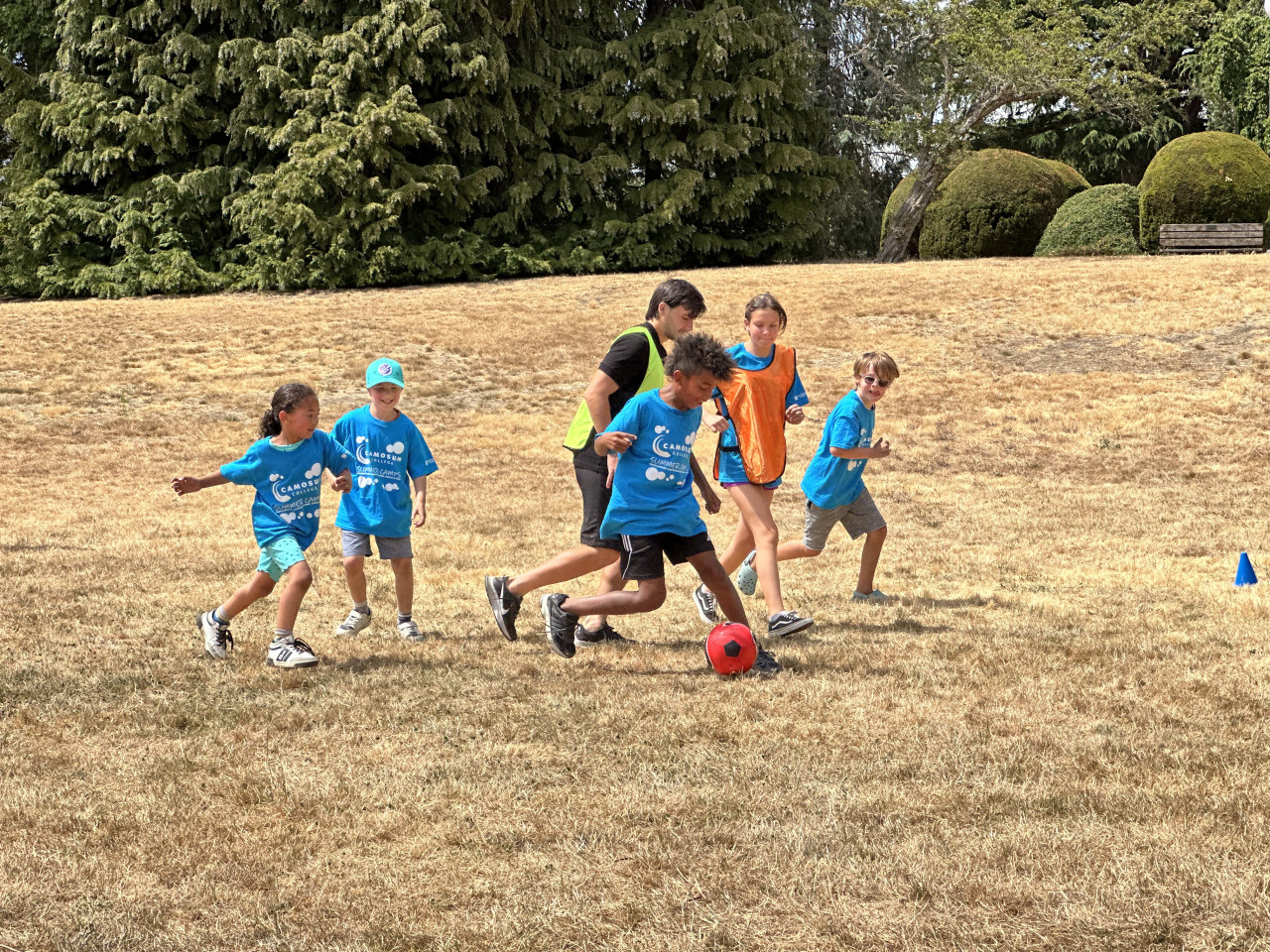 Camosun Summer Sports Camp kids playing soccer with Pacific FC players.