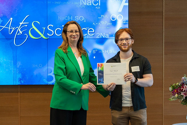 Debbie Hlady, Dean of the School of Arts and Sciences, poses with a student who is proudly holding a certificate.